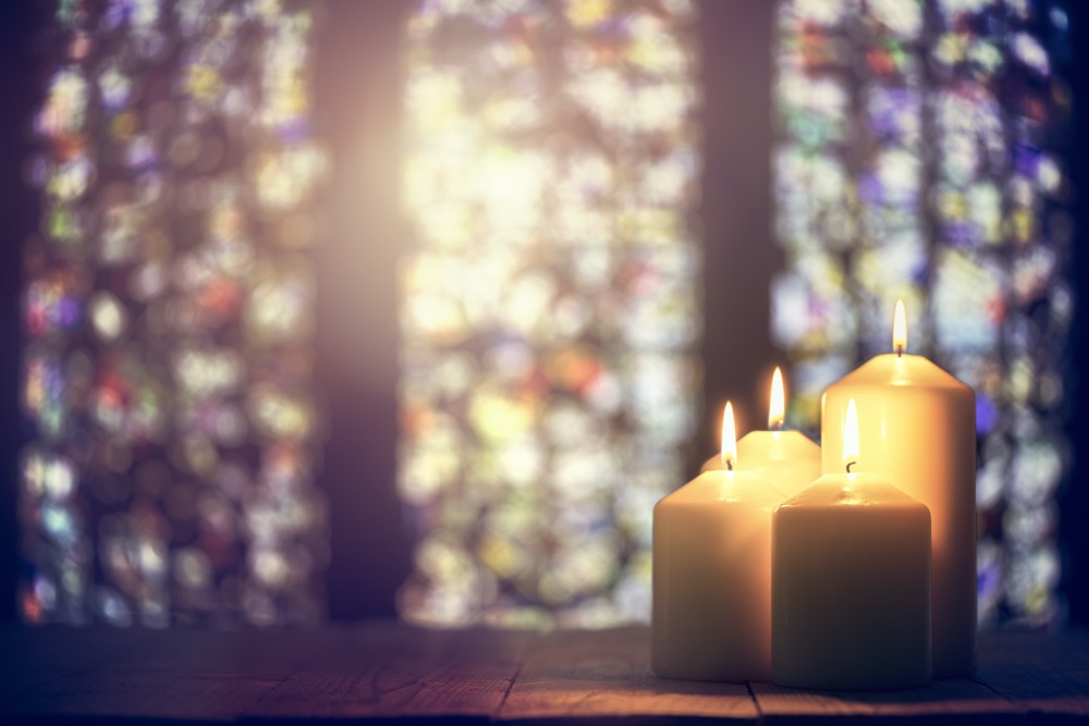 Candles near a stained glass window in a church