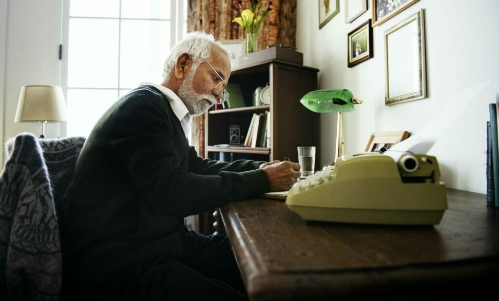 Man wiriting at his desk at home, leaving a legacy in his will